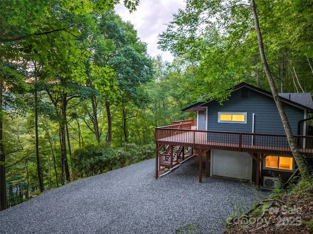 1065 Oak Ridge Ln, Mars Hill, NC 28754 - view of property exterior with a deck, stairway, a garage, gravel driveway, and a forest view