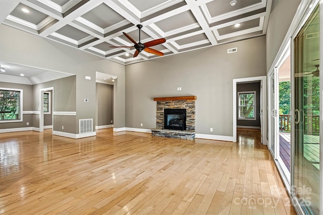 3450 4th Street Blvd NW, Hickory, NC 28601 - unfurnished living room featuring a high ceiling, a ceiling fan, light wood-style floors, coffered ceiling, and a stone fireplace