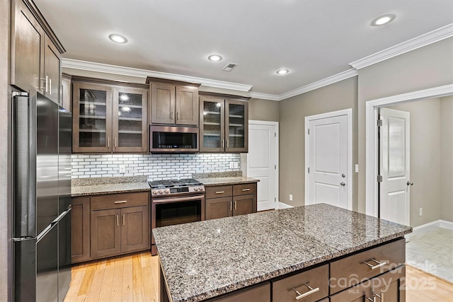 3450 4th Street Blvd NW, Hickory, NC 28601 - kitchen featuring appliances with stainless steel finishes, tasteful backsplash, light stone countertops, ornamental molding, and light wood-style flooring