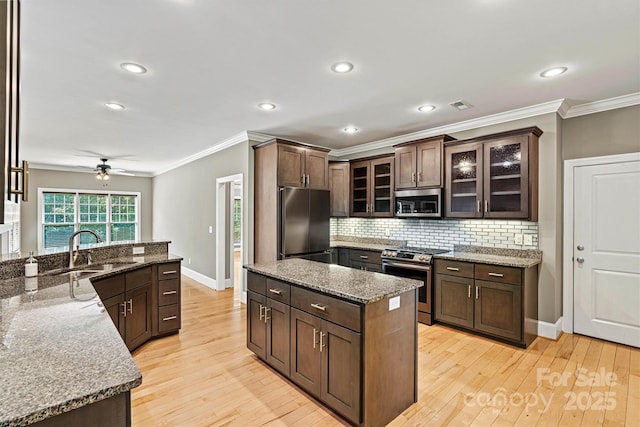 3450 4th Street Blvd NW, Hickory, NC 28601 - kitchen with stainless steel appliances, crown molding, light wood-style floors, decorative backsplash, and ceiling fan