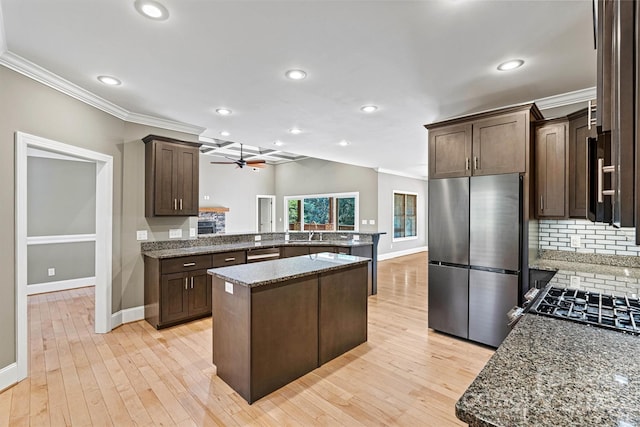 3450 4th Street Blvd NW, Hickory, NC 28601 - kitchen featuring appliances with stainless steel finishes, a peninsula, crown molding, dark brown cabinets, and tasteful backsplash