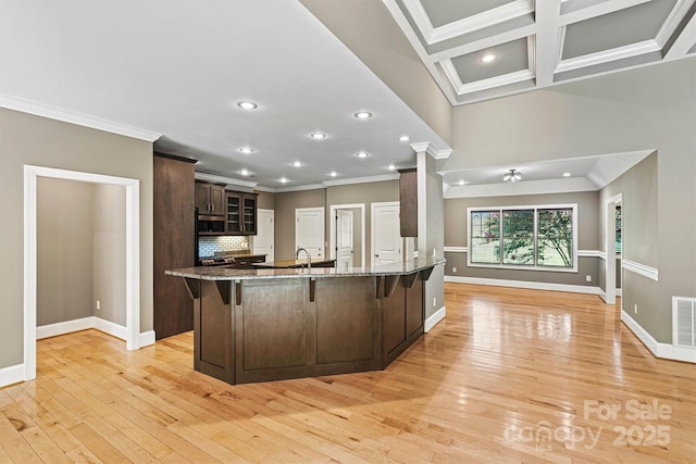 3450 4th Street Blvd NW, Hickory, NC 28601 - kitchen with crown molding, a breakfast bar, glass insert cabinets, light wood-style floors, and stainless steel microwave