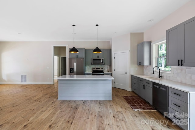 939 Rocky Mountain Rd, Lake Toxaway, NC 28747 - kitchen with stainless steel appliances, gray cabinets, backsplash, and light countertops