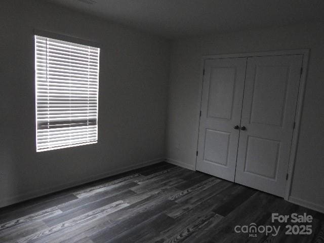 248 Mills Ave, Troutman, NC 28166 - unfurnished bedroom with dark wood-style flooring and a closet