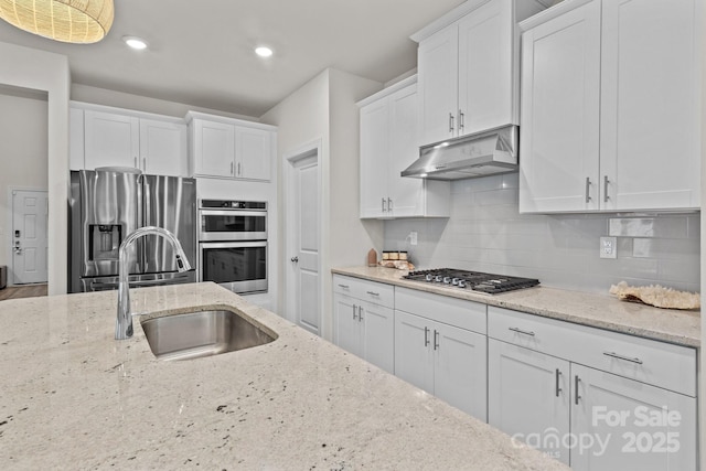9021 Myrna Dr, Gastonia, NC 28056 - kitchen with stainless steel appliances, under cabinet range hood, white cabinets, backsplash, and light stone countertops