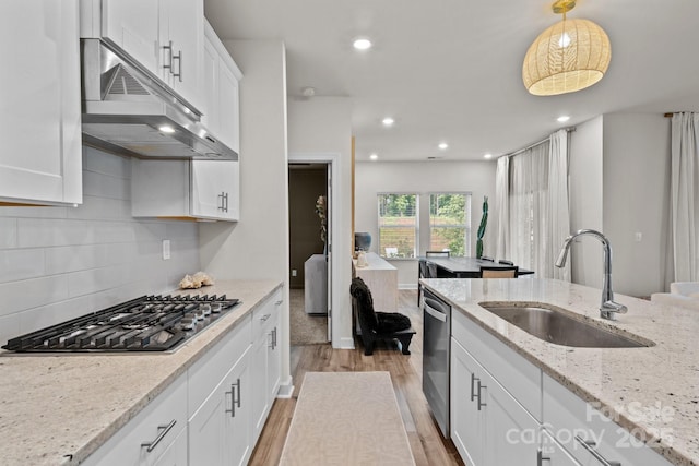9021 Myrna Dr, Gastonia, NC 28056 - kitchen with appliances with stainless steel finishes, under cabinet range hood, light wood-style floors, white cabinetry, and tasteful backsplash