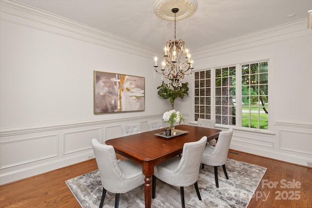 1505 Hawkstone Dr, Waxhaw, NC 28173 - dining room featuring a chandelier, ornamental molding, wood finished floors, a wainscoted wall, and a decorative wall