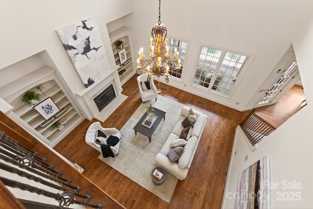 1505 Hawkstone Dr, Waxhaw, NC 28173 - living area with wood finished floors, a high ceiling, a high end fireplace, a chandelier, and built in features