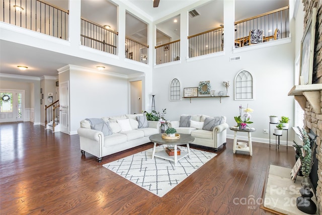 208 Canoe Pole Ln, Mooresville, NC 28117 - living area with a towering ceiling, wood finished floors, stairway, ornamental molding, and a stone fireplace