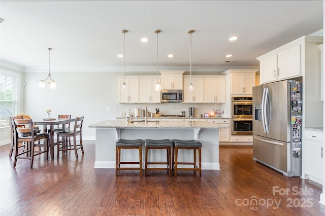 208 Canoe Pole Ln, Mooresville, NC 28117 - kitchen with appliances with stainless steel finishes, ornamental molding, dark wood finished floors, an island with sink, and light stone countertops