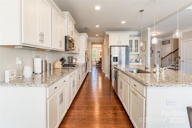 208 Canoe Pole Ln, Mooresville, NC 28117 - kitchen with appliances with stainless steel finishes, crown molding, dark wood finished floors, a center island with sink, and white cabinetry