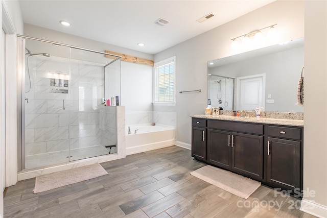 208 Canoe Pole Ln, Mooresville, NC 28117 - full bath featuring a bath, vanity, a stall shower, wood finished floors, and recessed lighting