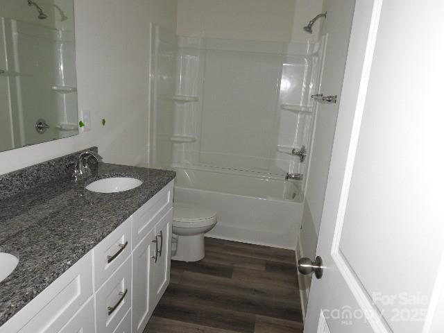 232 Sugar Hill Rd, Troutman, NC 28166 - full bathroom featuring double vanity, wood finished floors, and shower / bathtub combination