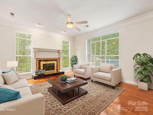 15139 Wiltshire Manor Dr, Charlotte, NC 28278 - living room with plenty of natural light, a ceiling fan, wood finished floors, crown molding, and a fireplace