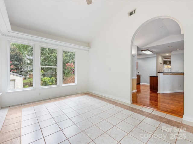15139 Wiltshire Manor Dr, Charlotte, NC 28278 - unfurnished room with vaulted ceiling, light tile patterned flooring, arched walkways, inlaid floor details, and a raised ceiling