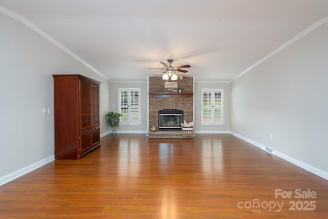 1408 Wildwood Dr, Kannapolis, NC 28081 - unfurnished living room featuring ceiling fan, healthy amount of natural light, wood finished floors, ornamental molding, and a stone fireplace