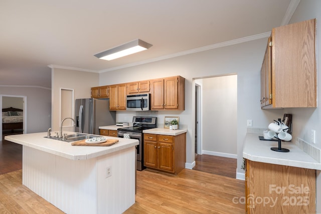 1408 Wildwood Dr, Kannapolis, NC 28081 - kitchen featuring stainless steel appliances, light wood-type flooring, ornamental molding, light countertops, and a center island with sink