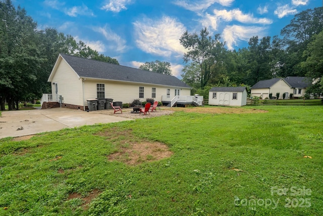 1408 Wildwood Dr, Kannapolis, NC 28081 - back of property featuring a shed, an outdoor fire pit, a lawn, a wooden deck, and crawl space