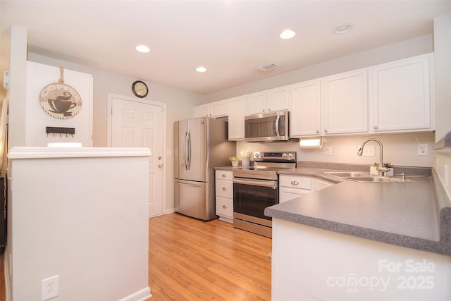 2620 Brackley Pl NW, Concord, NC 28027 - kitchen with stainless steel appliances, white cabinets, recessed lighting, and light wood-type flooring