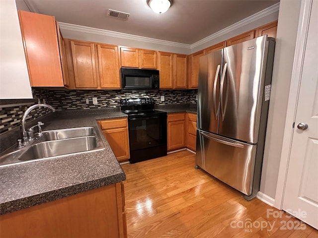5236 Hilltop Rd, Jamestown, NC 27282 - kitchen featuring black appliances, dark countertops, backsplash, crown molding, and light wood-style floors