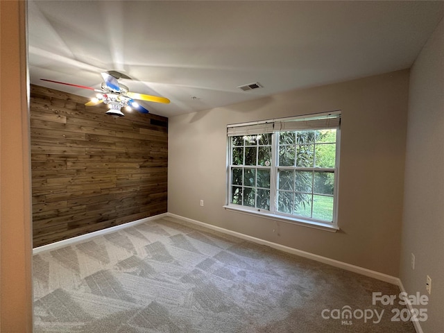 5236 Hilltop Rd, Jamestown, NC 27282 - spare room with wood walls, a ceiling fan, and carpet flooring