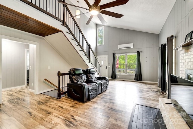 155 Notta Rd, Franklin, NC 28734 - living area featuring a wall mounted AC, high vaulted ceiling, ceiling fan, wood finished floors, and a brick fireplace