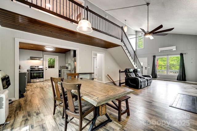 155 Notta Rd, Franklin, NC 28734 - dining area with a ceiling fan, a wall mounted air conditioner, light wood-style floors, stairway, and high vaulted ceiling