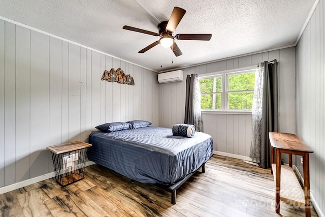155 Notta Rd, Franklin, NC 28734 - bedroom featuring an AC wall unit, wood finished floors, a textured ceiling, and ceiling fan
