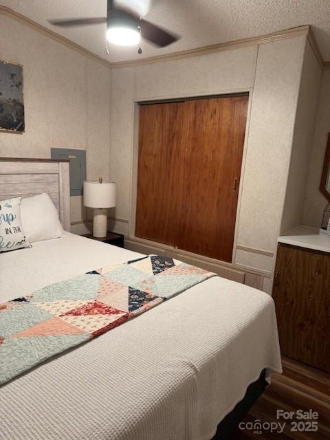 103 Holly Harbor Trl Unit 348A, Mount Gilead, NC 27306 - bedroom with ornamental molding, wood finished floors, a ceiling fan, a closet, and a textured ceiling