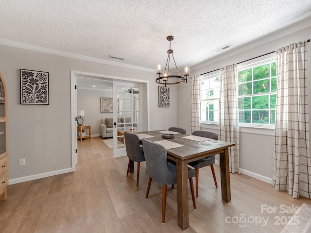 607 W School St, Maiden, NC 28650 - dining room with a textured ceiling, a chandelier, ornamental molding, and light wood-style floors