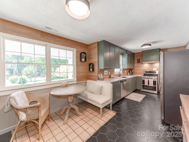 607 W School St, Maiden, NC 28650 - kitchen featuring appliances with stainless steel finishes, a textured ceiling, light countertops, and dark tile patterned flooring