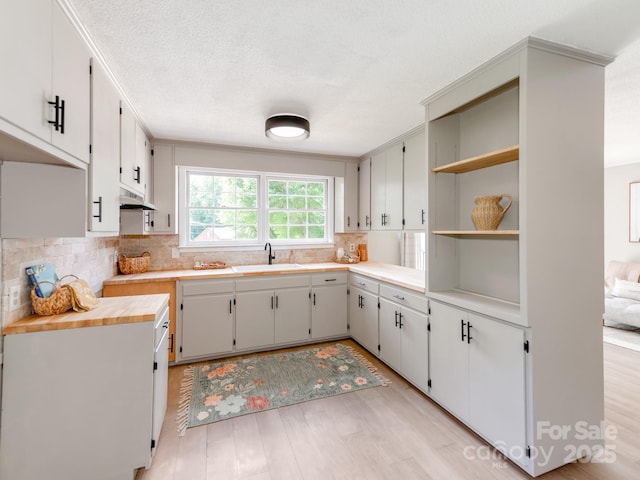 607 W School St, Maiden, NC 28650 - kitchen with light wood-type flooring, tasteful backsplash, open shelves, light countertops, and white cabinets