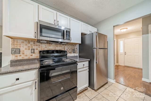 8027 Sherington Way, Charlotte, NC 28227 - kitchen featuring stainless steel appliances, white cabinetry, decorative backsplash, light tile patterned flooring, and a textured ceiling