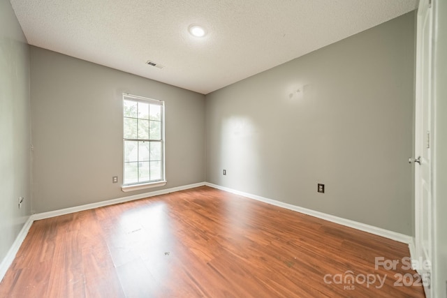 8027 Sherington Way, Charlotte, NC 28227 - unfurnished room with wood finished floors and a textured ceiling