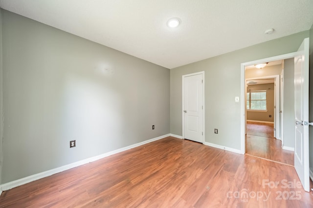 8027 Sherington Way, Charlotte, NC 28227 - unfurnished bedroom featuring wood finished floors and baseboards