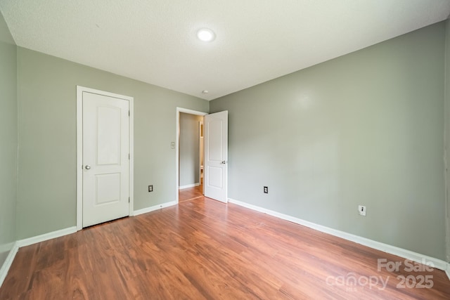 8027 Sherington Way, Charlotte, NC 28227 - unfurnished bedroom with wood finished floors and baseboards