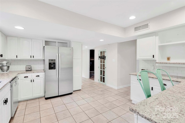 15804 Fairfield Dr, Matthews, NC 28104 - kitchen featuring stainless steel appliances, open shelves, tasteful backsplash, light stone countertops, and white cabinets