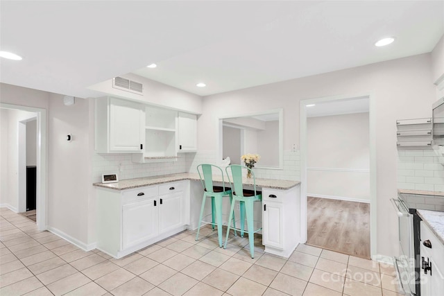 15804 Fairfield Dr, Matthews, NC 28104 - kitchen with light tile patterned floors, backsplash, white cabinets, light stone counters, and recessed lighting
