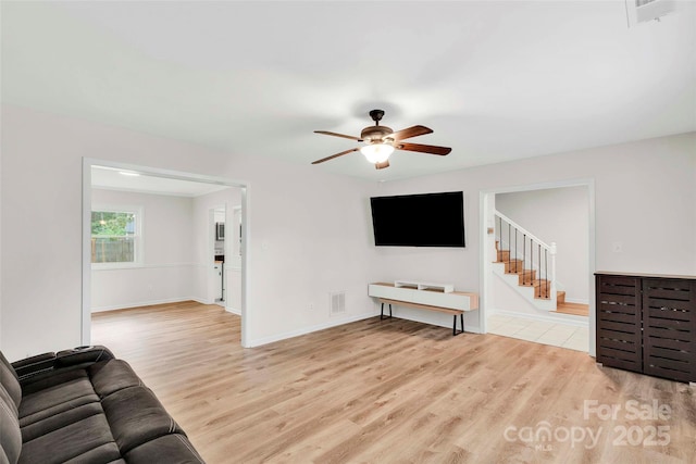 15804 Fairfield Dr, Matthews, NC 28104 - living area featuring a ceiling fan, light wood finished floors, and stairs