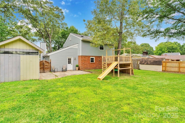 15804 Fairfield Dr, Matthews, NC 28104 - rear view of house featuring a storage shed, brick siding, a fenced backyard, and a playground
