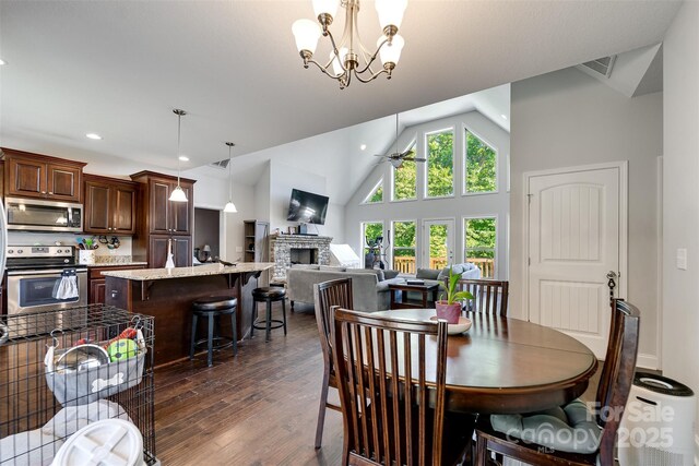 266 Egret Ln, Sylva, NC 28779 - dining space with dark wood-type flooring, recessed lighting, a fireplace, ceiling fan, and a chandelier