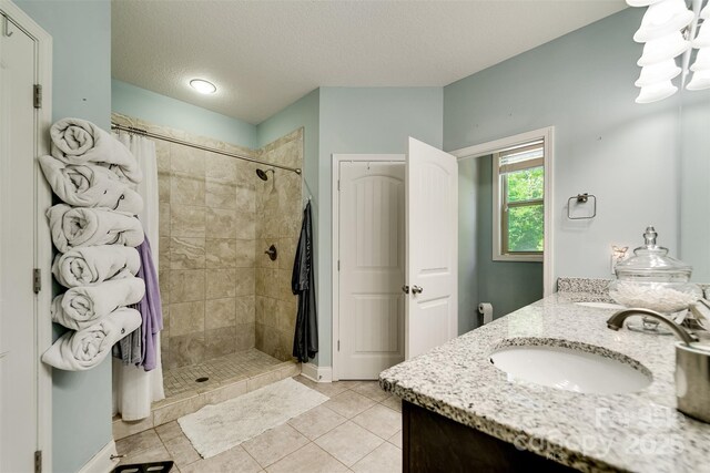 266 Egret Ln, Sylva, NC 28779 - bathroom with double vanity, a tile shower, a textured ceiling, and tile patterned flooring