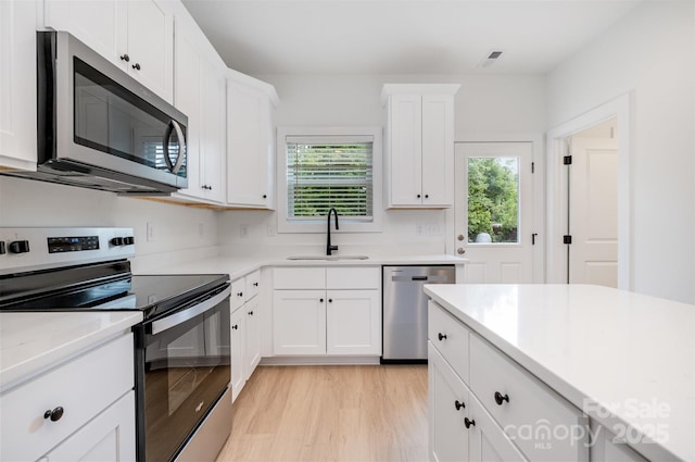794 Stanley Spencer Mtn Rd, Gastonia, NC 28056 - kitchen featuring appliances with stainless steel finishes, healthy amount of natural light, white cabinetry, and light wood finished floors