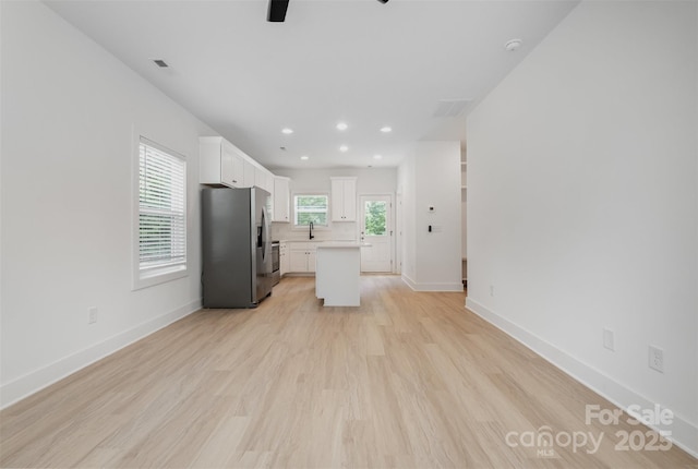 794 Stanley Spencer Mtn Rd, Gastonia, NC 28056 - kitchen with stainless steel fridge, a ceiling fan, light countertops, white cabinetry, and light wood-style flooring