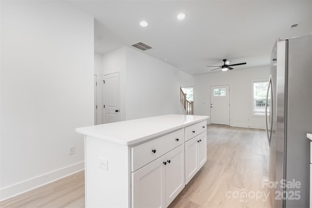 794 Stanley Spencer Mtn Rd, Gastonia, NC 28056 - kitchen with freestanding refrigerator, light wood finished floors, ceiling fan, white cabinetry, and a center island