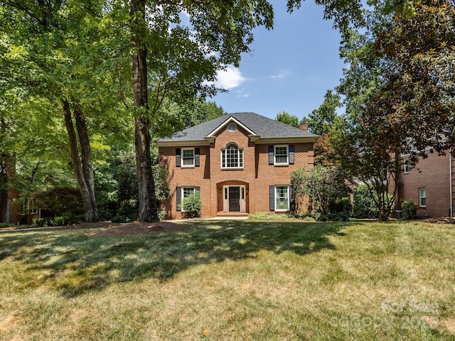 9413 Tillot Dr, Matthews, NC 28105 - colonial inspired home with brick siding, a chimney, and a front yard