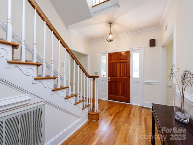 9413 Tillot Dr, Matthews, NC 28105 - foyer featuring light wood-style flooring, stairs, and crown molding