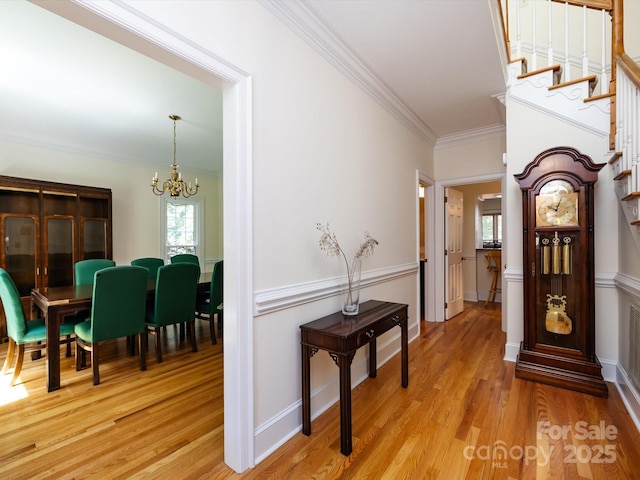 9413 Tillot Dr, Matthews, NC 28105 - hallway featuring crown molding, a chandelier, light wood-style flooring, and stairway