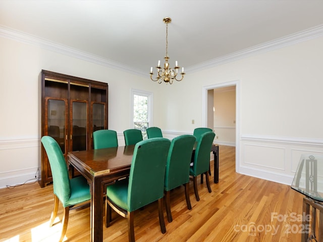 9413 Tillot Dr, Matthews, NC 28105 - dining room with crown molding, a chandelier, light wood-style floors, and wainscoting