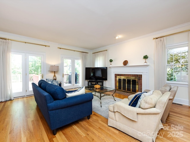 9413 Tillot Dr, Matthews, NC 28105 - living room featuring plenty of natural light, ornamental molding, light wood finished floors, and a brick fireplace